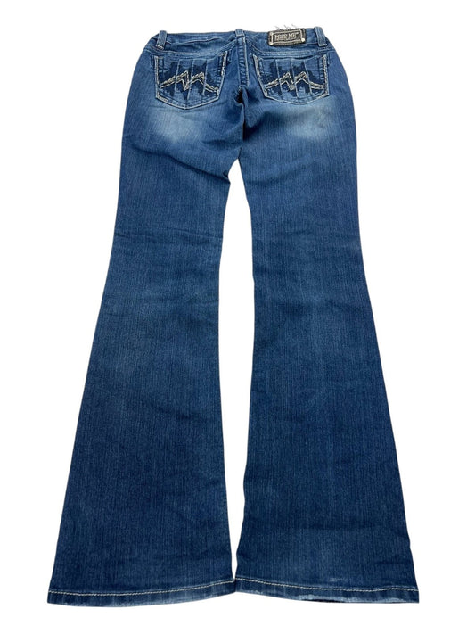 Eine blaue Schlagjeans „Miss Me Mid Rise Boot“ von ZAZA Resell (B28 x L34), von hinten gezeigt, mit verblassten Details und Ziernähten an den Gesäßtaschen. Größe 28, Maße auf Anfrage, Zustand 8/10.
