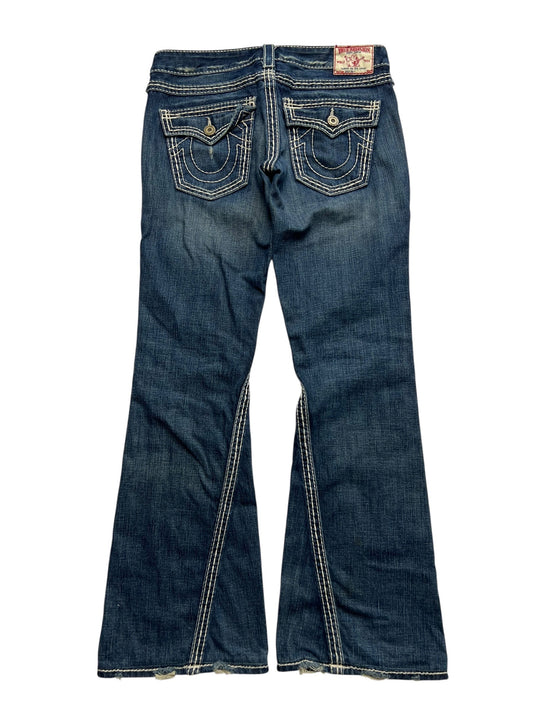 True Religion Joey Big T - Low Rise Boot Jeans von ZAZA resell in Größe 28/M, hier von hinten mit ausgestelltem Bein, weißen Kontrastnähten, dekorativen geknöpften Pattentaschen und leicht ausgefranstem Saum-ultra rare in Bundweite 40.
