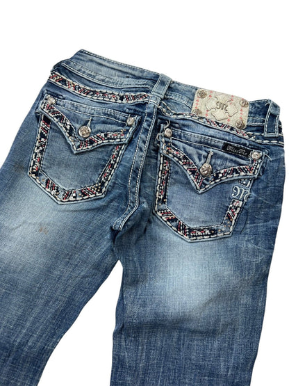 Miss Me Low Rise Straight Jeans von ZAZA resell in Blau mit Distressed-Look, Ziernähten, gemustertem Gesäßtaschenbesatz, silbernen Knöpfen und einem gemusterten Markenpatch aus Leder. Größe 25 (XS/S), Bundweite 34 cm, Außenbeinlänge 104 cm.