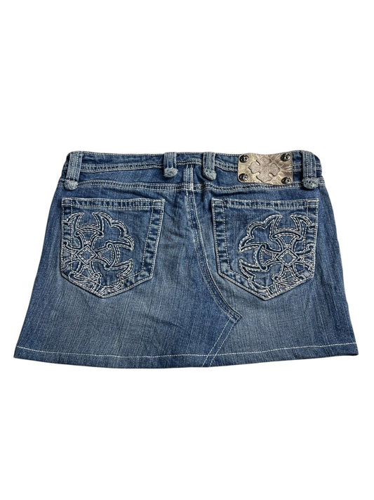 Der Miss Me Skirt von ZAZA resell ist ein blauer Denim-Mini mit zwei Gesäßtaschen, weißen Ziernähten und einem Aufnäher in braunem Schlangenhautmuster mit Metallnieten am Bund. Größe 28 (M).