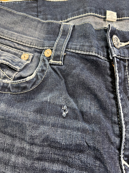 Eine Nahaufnahme der True Religion Straight Jeans (W36 x L36) von ZAZA Resell zeigt die Vordertasche, den Knopf, die Gürtelschlaufe und eine kleine Reparatur in der Nähe der Tasche; der Stoff ist abgenutzt und leicht verblasst – „Zustand“ weist auf sanften Gebrauch hin.