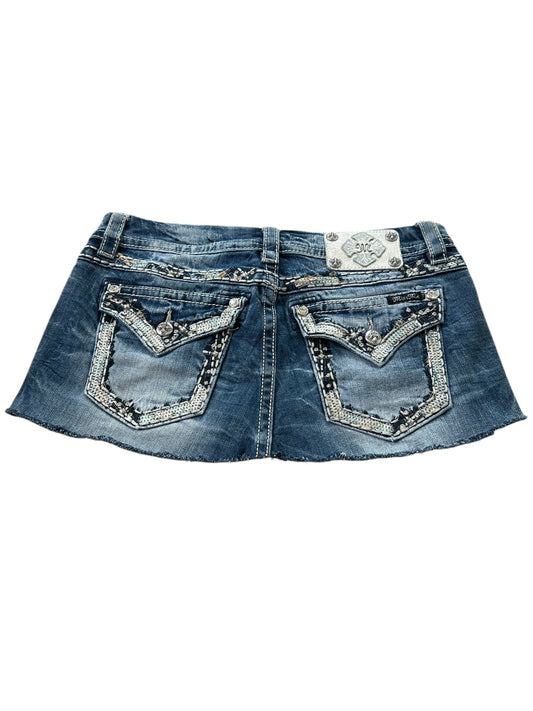 Der Miss Me Skirt | W30 von ZAZA resell ist ein blauer Denim-Mini mit ausgefranstem Saum, Gesäßtaschen mit verzierten Designs, Kontrastnähten, einem dekorativen Markenpatch am Bund und detaillierter Bundweite für eine perfekte Passform.