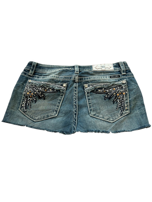 Der Miss Me Skirt | W31 von ZAZA Resell ist ein maßgeschneiderter Rock-Jeans-Minirock mit ausgefranstem Saum und verzierten Gesäßtaschen mit Perlen- und Paillettenmuster.
