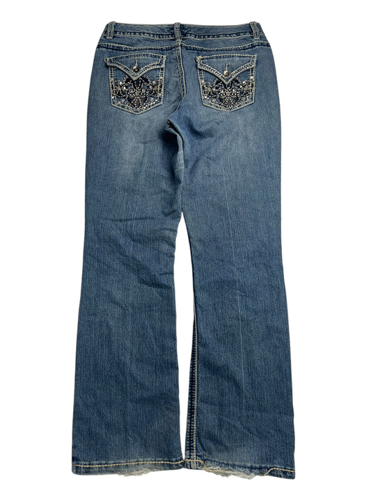 Die Nine West Mid Rise Boot Jeans (W31 x L33) von ZAZA Resell liegen flach und zeigen auf der Rückseite zwei Taschen mit Ziernähten und Verzierungen sowie einen leicht ausgestellten Saum für zusätzlichen Stil.