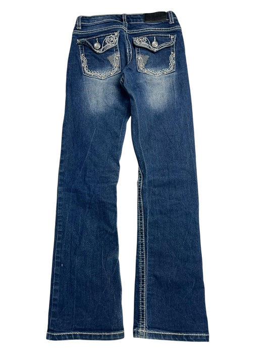 Die ZAZA-Resell-Jeans Pure Western Mid Rise Slim Boot (B23 x L26) ist ein blauer Kinder-Denim mit weitem Bein, weißen Kontrastnähten, verwaschenen Details und dekorativen Pattentaschen mit Knöpfen. Die Abbildung zeigt die Rückseite flach, um die Größenangaben wie Bundweite oder Außenbeinlänge zu bestimmen.