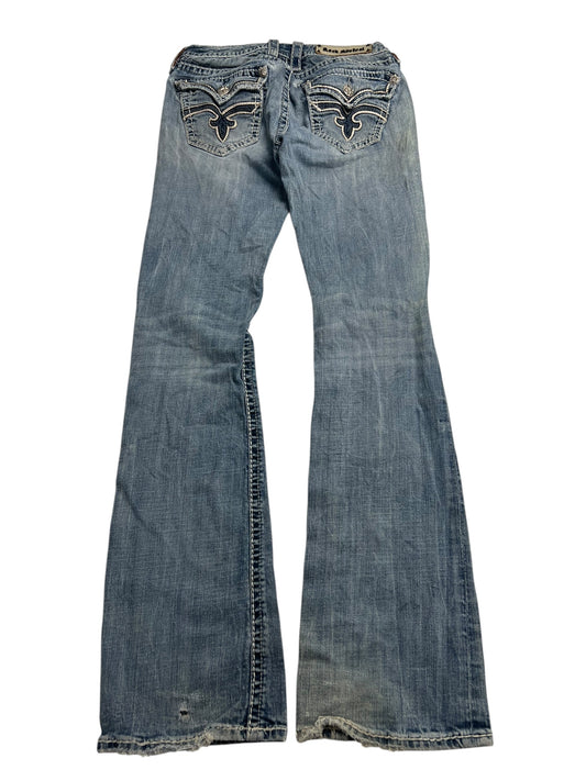 Rock Revival Low Rise Boot Jeans von ZAZA Resell, W29 x L34, in Hellblau mit abgenutztem Finish und bestickten Gesäßtaschen, flach auf weißem Hintergrund präsentiert.