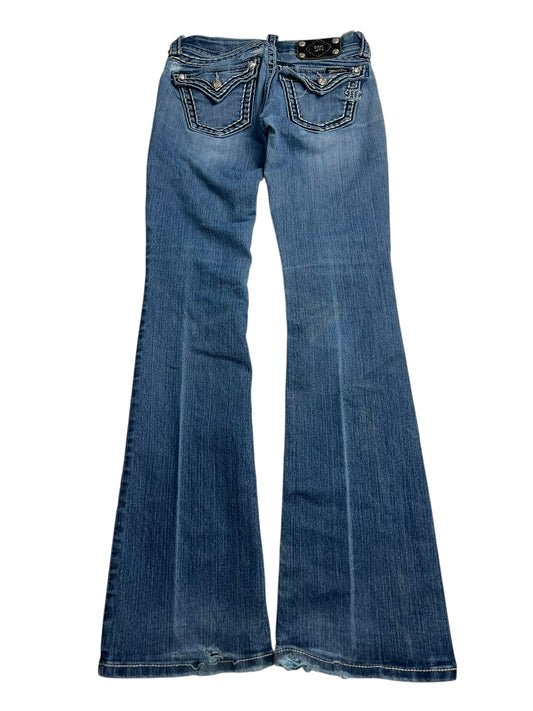 Der von ZAZA weiterverkaufte Miss Me Low Rise Boot (B25 x L30) besteht aus blauem Denim im Bootcut-Schnitt, hat verwaschene Details, Kontrastnähte, Taschen vorne und hinten sowie Used-Look-Säume für einen authentischen Used-Look.