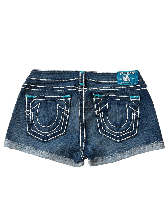 True Religion Shorts | 30 (M) von ZAZA resell: blaue Denim-Shorts mit weißen Nähten, zwei Gesäßtaschen mit geschwungenem Design, blaues Markenlabel über der rechten Tasche, Bundweite 40 cm, und Außenbeinlänge 26 cm für eine perfekte Passform.