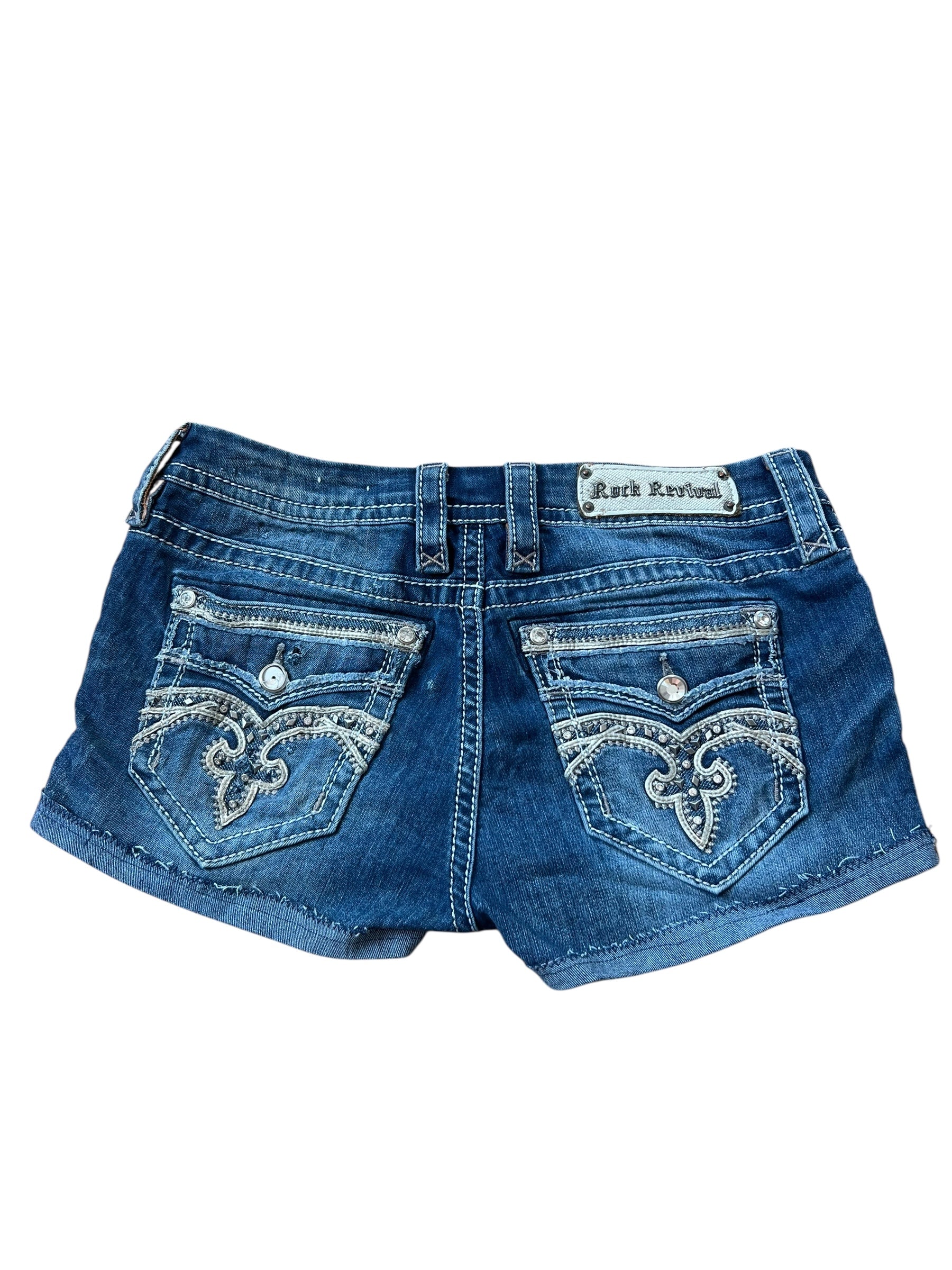 Rock Revival Shorts von ZAZA resell | 30 (M/L): Blaue Denim Custom Shorts mit umgeschlagenen Bündchen, dekorativen Nähten an der Gesäßtasche, silbernen Knöpfen, einem Markenlabel über der rechten Tasche, Bundweite 41 und Labelgröße 30.