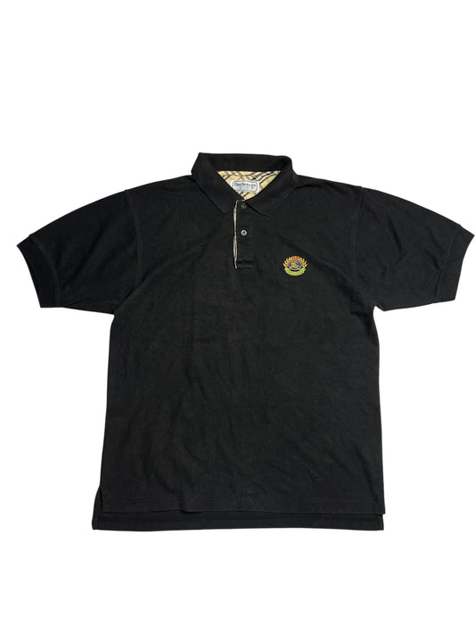 Burberry Polo Shirt | L von ZAZA wiederverkaufen: Schwarzes kurzärmeliges Polohemd mit Kragen, Knöpfen und kleinem mehrfarbigen gestickten Logo auf der linken Brust. Zustand 9/10, Etikettengröße L.