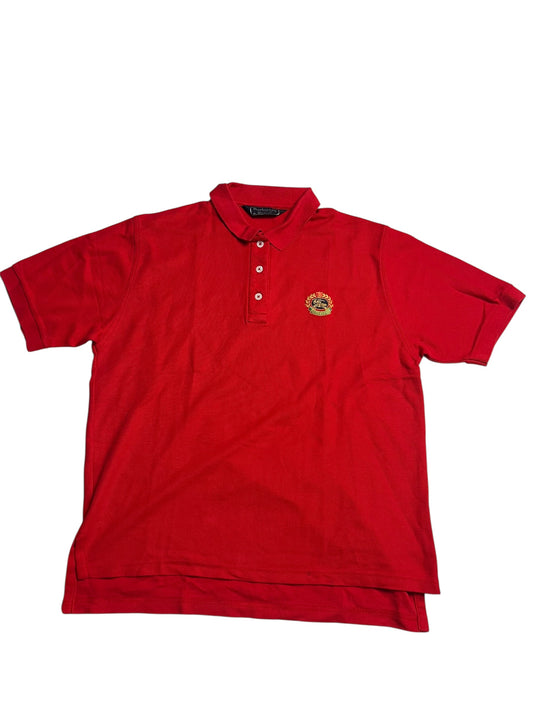 Ein rotes Burberry Polo Shirt (M) von ZAZA resell mit kurzen Ärmeln, Kragen, drei Knöpfen und einem kleinen gestickten Logo auf der linken Brust; Zustand 9/10, abgebildet auf weißem Hintergrund.