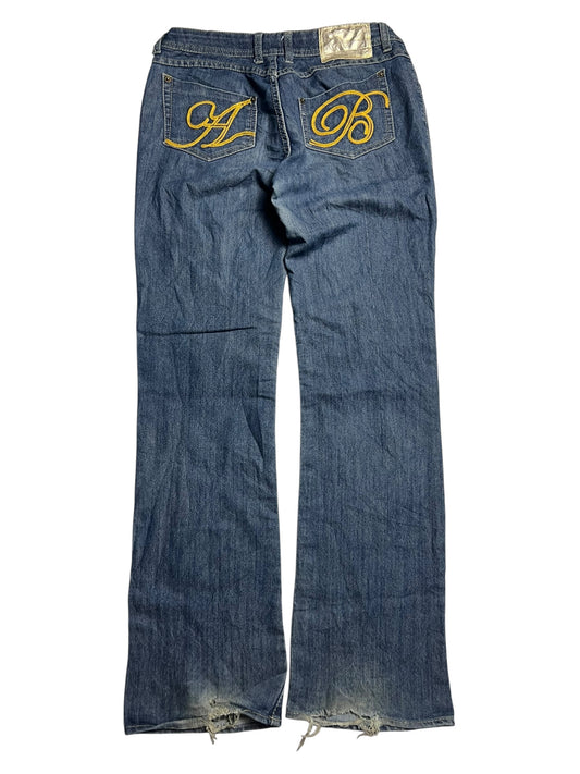 Die Apple Bottoms Mid Rise Boot Jeans von ZAZA resell zeichnet sich durch blauen Denim, große gelbe A- und B-Stickereien auf den Gesäßtaschen, ausgefranste Säume und Passformdetails wie Bundweite und Außenbeinlänge für den perfekten Sitz aus.