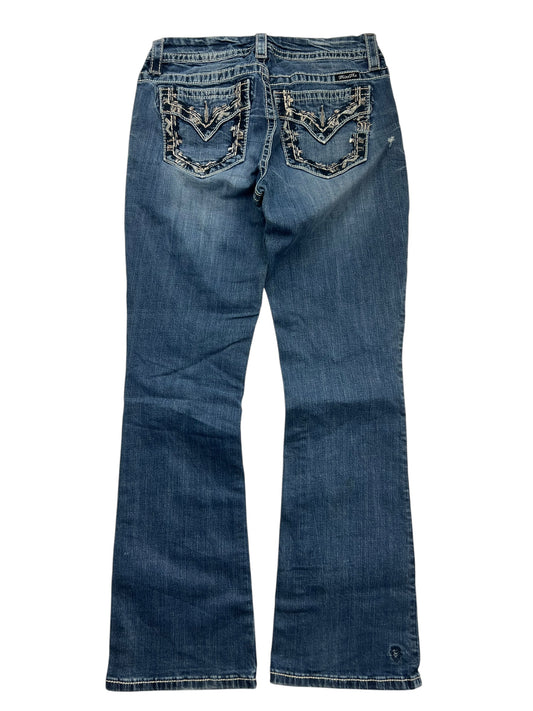 Die ZAZA resell Miss Me Mid Rise Curvy Boot in Größe 28 (M) ist eine blaue Denim-Jeans mit dekorativ bestickten Gesäßtaschen, einem leicht ausgestellten Bein und einem Schnitt für großen Hintern für eine bequeme, schmeichelnde Passform.