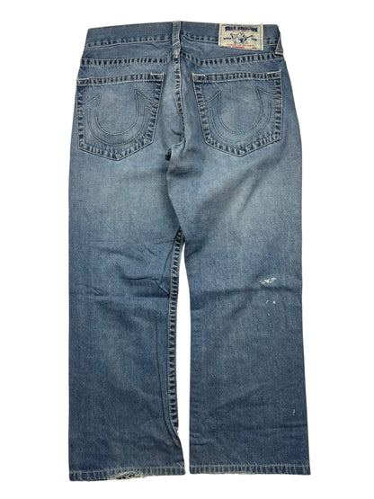 Ein Paar True Religion Straight-Jeans (Größe 34 L) von ZAZA resell, abgebildet von hinten mit zwei bestickten Hufeisentaschen, einem Markenaufnäher am Bund, einem leicht abgenutzten Look und Angaben zu Bundweite und Außenbeinlänge.
