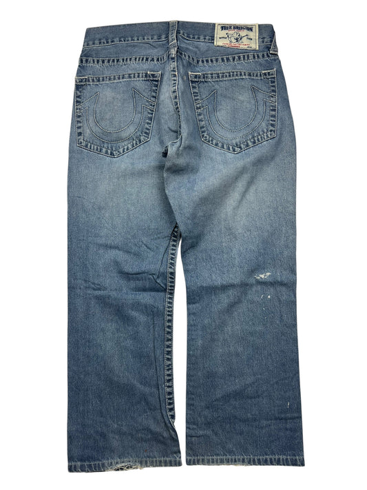 Ein Paar True Religion Straight-Jeans (Größe 34 L) von ZAZA resell, abgebildet von hinten mit zwei bestickten Hufeisentaschen, einem Markenaufnäher am Bund, einem leicht abgenutzten Look und Angaben zu Bundweite und Außenbeinlänge.