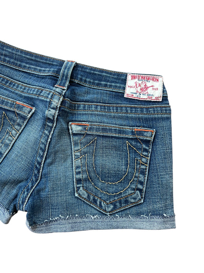 True Religion Shorts | 27 (S) von ZAZA wiederverkaufen: Shorts aus blauem Denim mit ausgefransten Säumen, orangefarbenen Nähten, einem weiß-roten Markenaufnäher am Bund und einer charakteristischen hufeisenförmigen Naht an der Gesäßtasche. Bundweite 37.