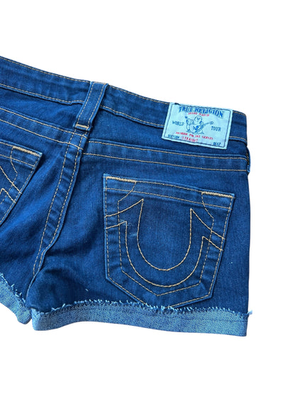 Eine Nahaufnahme der Rückseite der True Religion Shorts | 24 (XS) von ZAZA resell aus dunkelblauem Denim mit gelben Nähten, ausgefranstem Saum, Bundweite 33 und einem True Religion-Label über der rechten Tasche.