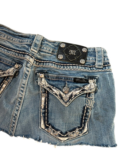 Nahaufnahme der Rückseite des blauen Miss Me Rocks in Größe 31 (M) von ZAZA resell mit Ziernähten, strassbesetzten Taschen und einem schwarzen Markenaufnäher aus Leder mit silbernen Nieten am Bund.
