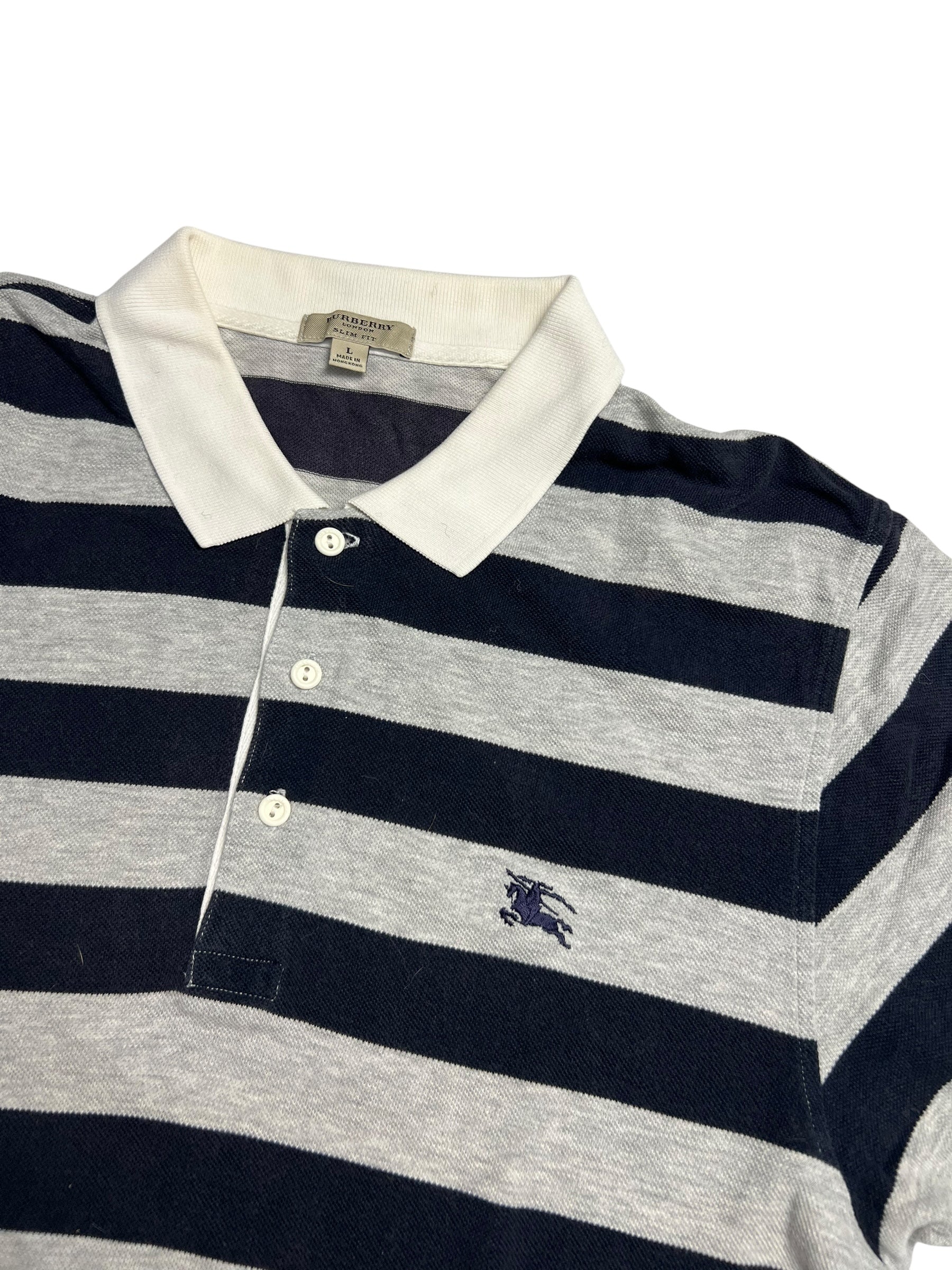 Burberry Polo Shirt | L von ZAZA wiederverkaufen: Breite marineblaue & hellgraue Streifen, weißer Kragen & Knöpfe, gesticktes Brustlogo. Maße in Zentimetern verfügbar. Flachgelegt auf weißem Hintergrund.