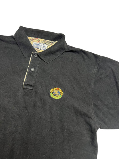 Burberry Polo Shirt | L von ZAZA resell: schwarz mit Kragen, Knopfleiste, gesticktem Wappenlogo auf der Brust, karierter Kragen mit Burberrys Label. Zustand 9/10. Labelgröße L. Maße in cm auf Anfrage.