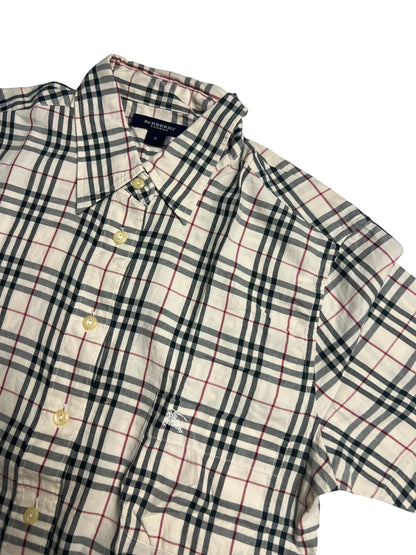 Das Burberry Hemd | S von ZAZA resell hat kurze Ärmel, klassische beige/schwarz/rote Karos, cremefarbene Knöpfe, eine Vordertasche und Zustand 9,5/10. Maße in cm auf Anfrage. Liegt flach auf einem weißen Hintergrund.