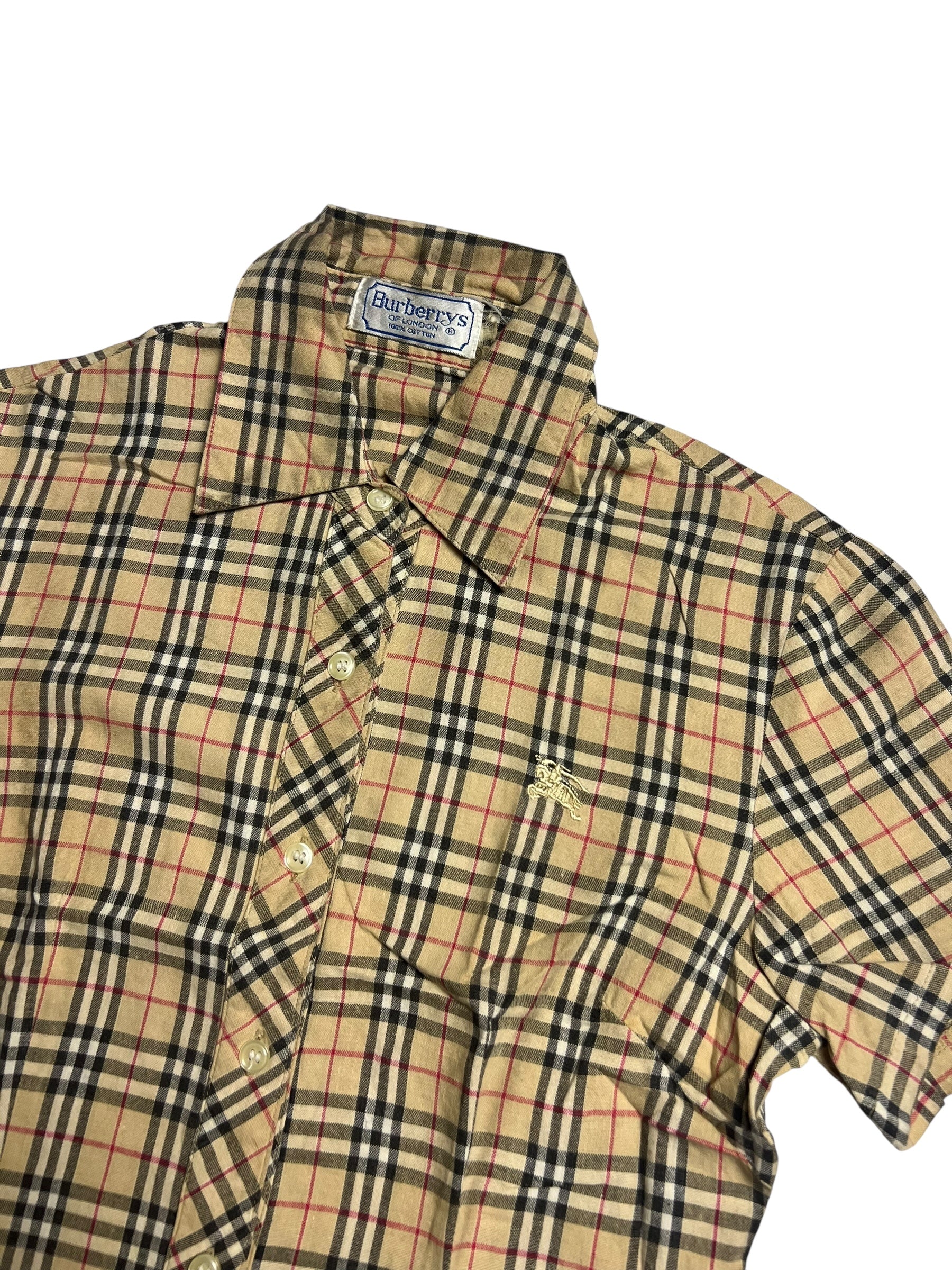 Das Burberry Hemd | S von ZAZA resell ist ein kurzärmeliges, kariertes Button-up mit Kragen, Brust-Logo, Burberrys-Label im Kragen sowie Maßen: Breite 40 cm und Länge 54 cm. Farben: Beige, Schwarz, Rot und Weiß.