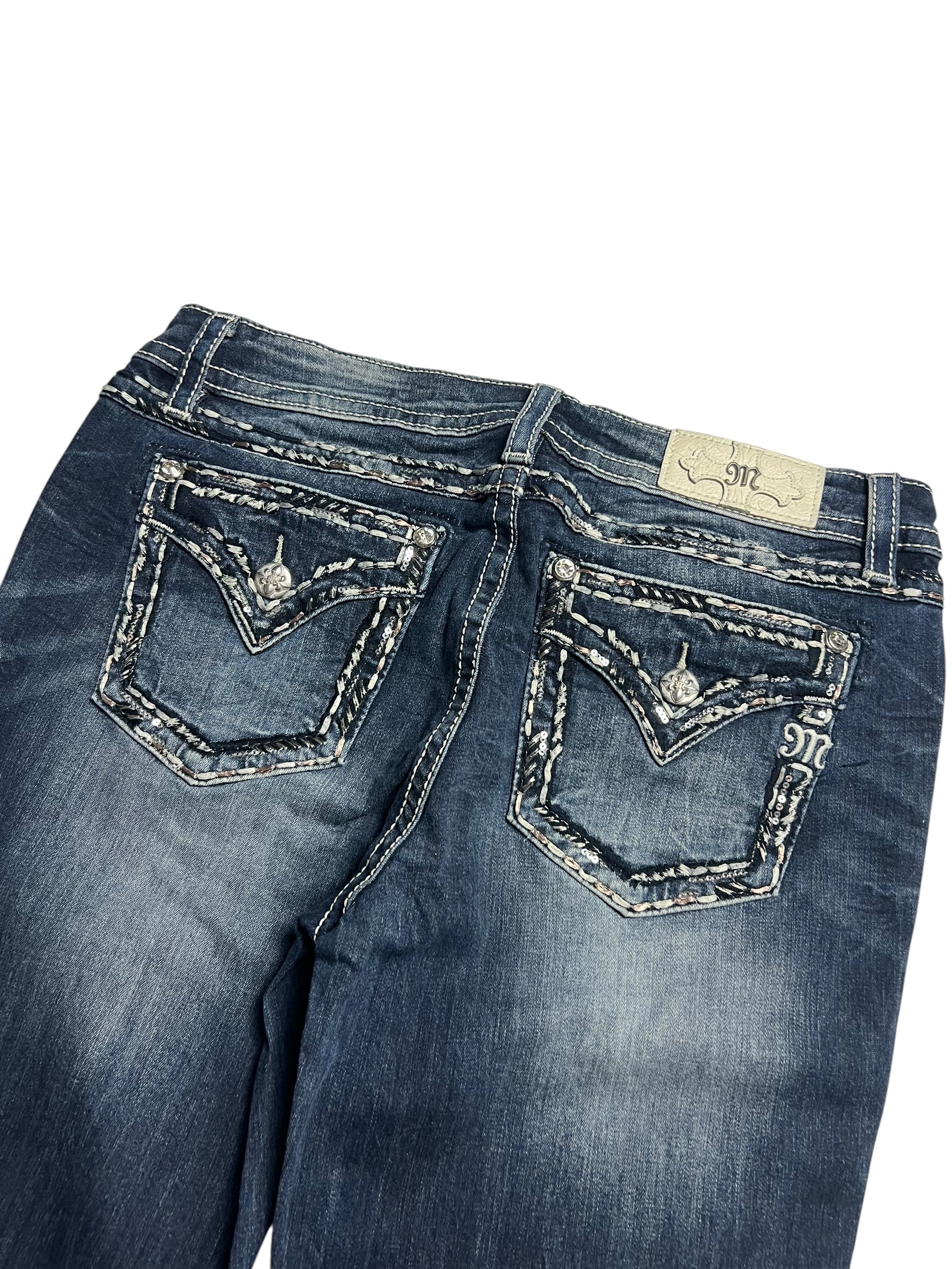 Miss Me Low Rise Boot Jeans von ZAZA resell in Größe 32 (L), dunkelblau mit ausgeblichenen Details, dekorativ aufgenähten Gesäßtaschen mit Knopfleiste, einem beigen Markenlabel über der rechten Tasche und präziser Bundweite für Komfort.