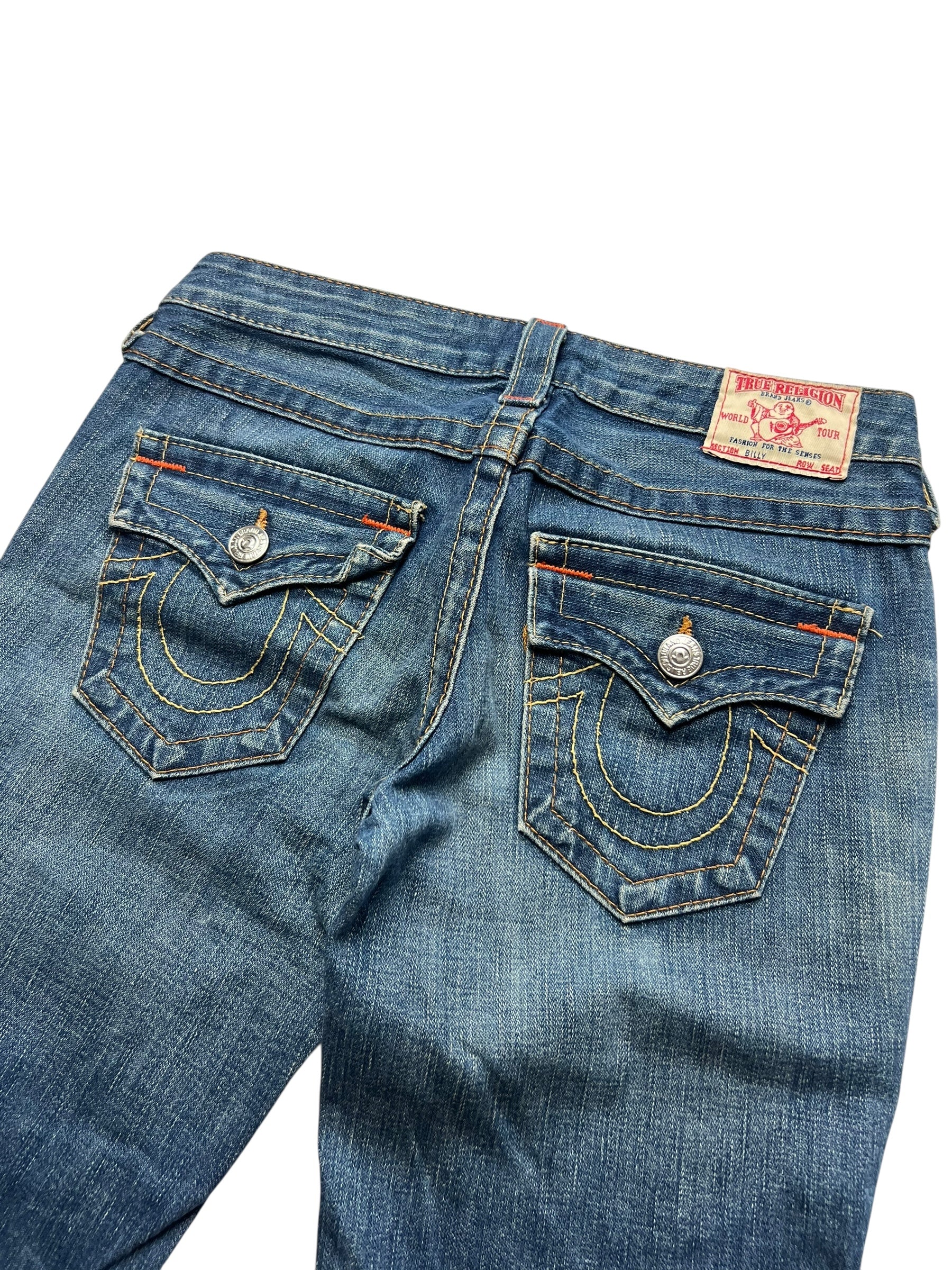 Die True Religion Billy - Low Rise Straight Jeans von ZAZA resell in Größe 26 (S/M) verfügt über markante Nähte, Gesäßpattentaschen mit Knöpfen, ein rot-weißes Markenlabel am Bund und eine bequeme Bundweite für den Alltag.