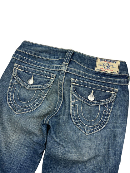 Eine Nahaufnahme der Rückseite der True Religion Skinny Jeans (Größe 25/S) von ZAZA resell aus blauem Denim mit weißen Nähten, Pattentaschen mit Knopfverschluss, einem Markenaufnäher am Bund und einem Labelgrößen-Tag in der Nähe des Größenbereichs.