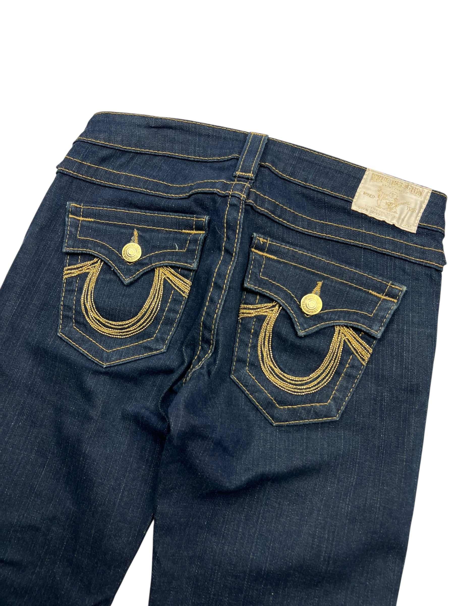 True Religion Becky Low Rise Boot Jeans von ZAZA resell in Größe 26 (S), dunkelblauer Denim mit goldenen Nähten, dekorativen Gesäßtaschenklappen, goldenen Knöpfen und hufeisenförmigen Stickereien. Seltenes Modell mit Bundweite 38.