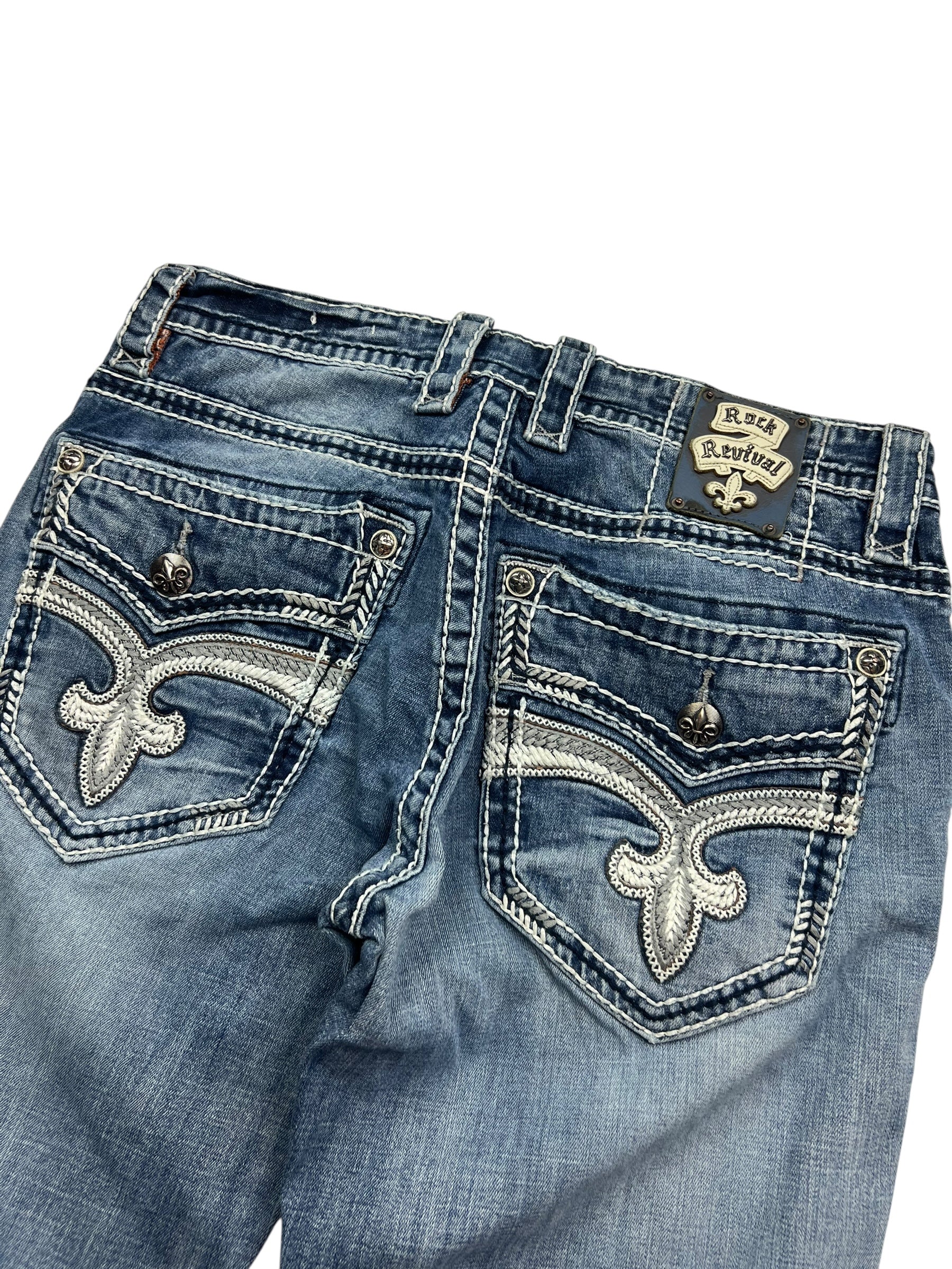 Rock Revival Relaxed Straight/Baggy Jeans von ZAZA resell, Größe 34 (M), mit blauem Denim, weißen Nähten, aufgestickten Fleur-de-Lis-Gesäßtaschen, Metallknöpfen und einem Markenetikett über der Tasche für hohen Tragekomfort.