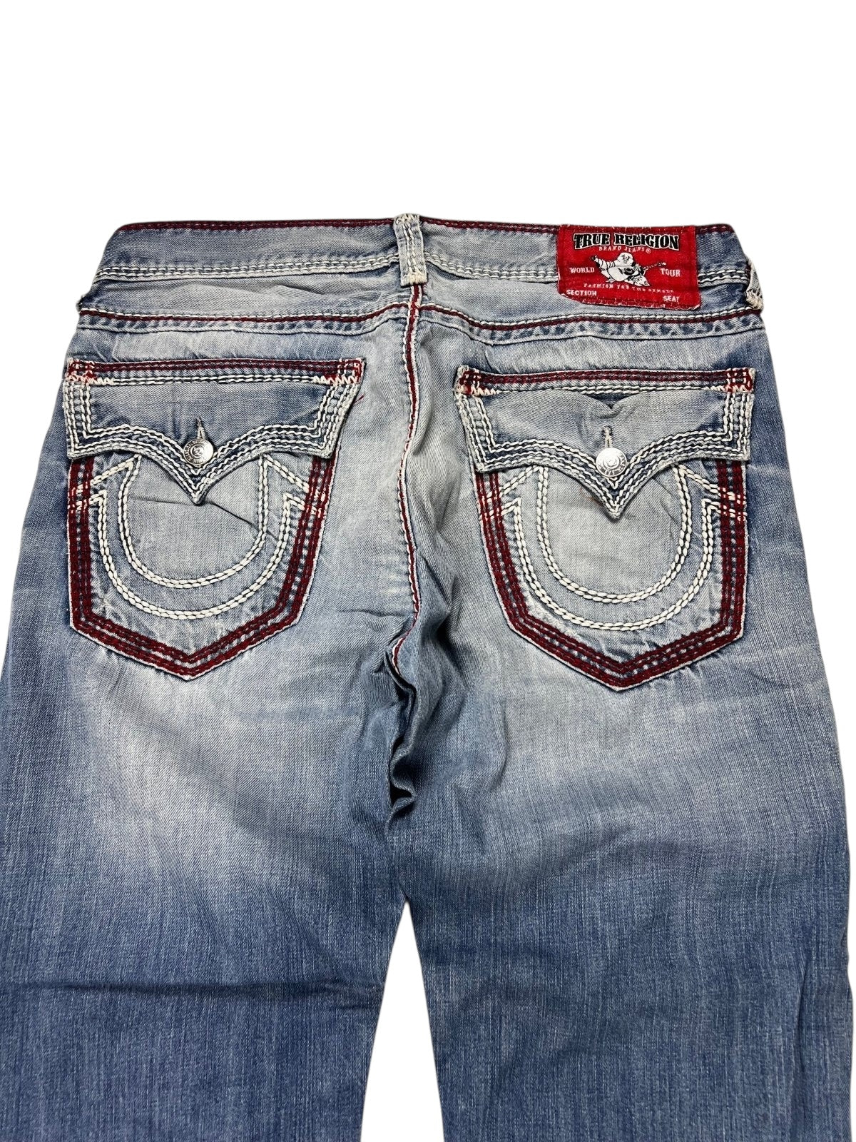 Ein Paar blaue True Religion Mega T Straight Jeans von ZAZA resell in Größe 34 (M), von hinten gesehen mit detaillierten weißen und roten Taschennähten und einem roten Markenetikett über der rechten Tasche für eine perfekte Passform.