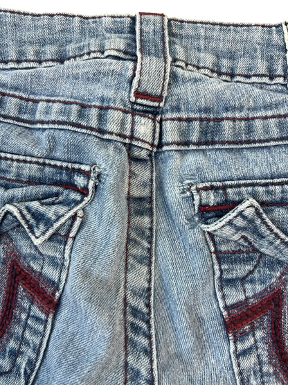 Nahaufnahme des hinteren Bunds und der Taschen der True Religion Shorts | 25 (XS) von ZAZA resell, mit blauem Denim, roten Ziernähten, einem Teil einer Gürtelschlaufe und zwei aufgenähten Gesäßtaschen. Bundweite 33 ist bekannt für individuelle Größenanpassung.