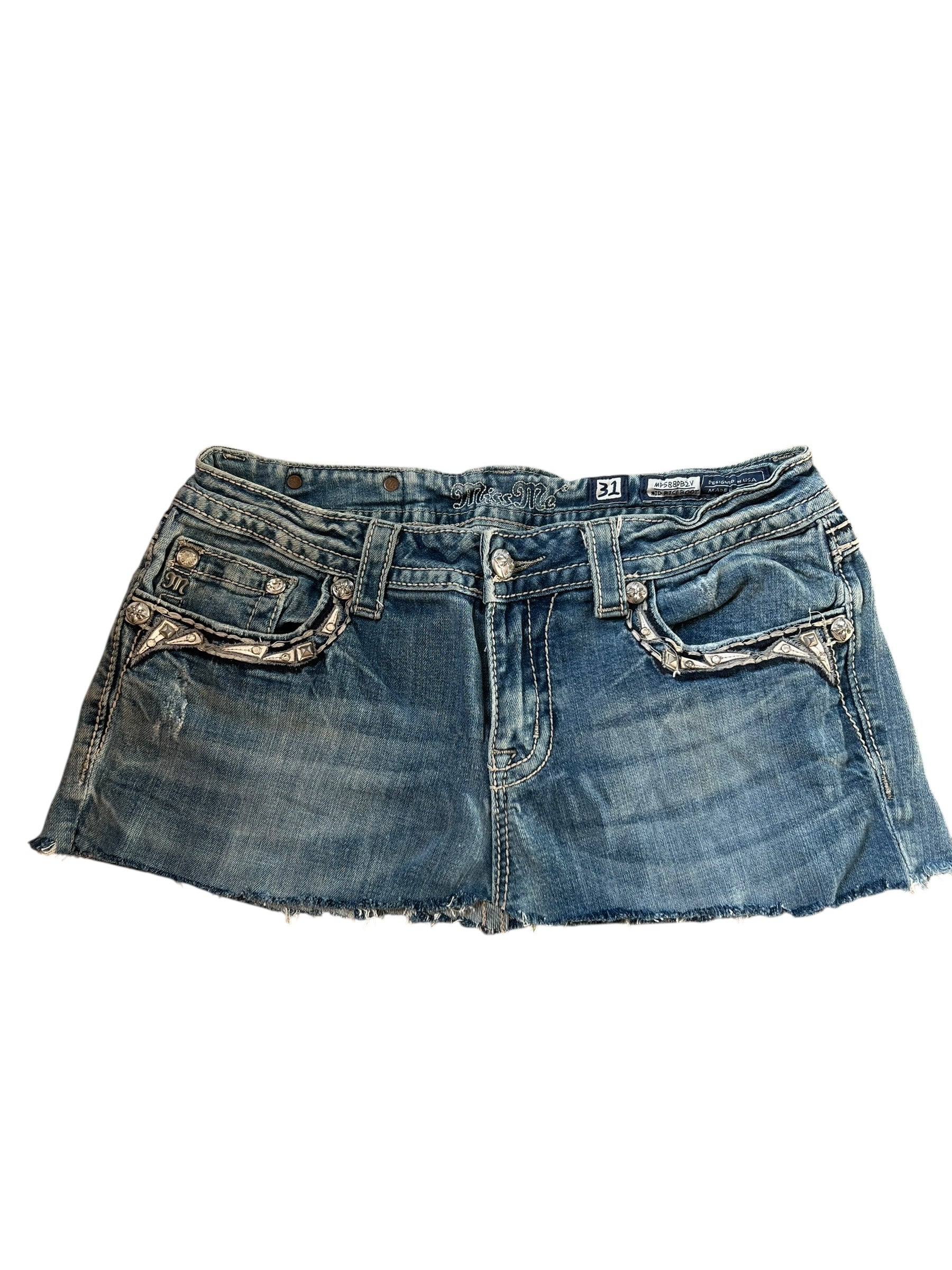 Ein Miss Me Rock von ZAZA resell in Größe 31 (M), blauer Denim mit ausgefransten Säumen, Vordertaschen, Gürtelschlaufen und verblichenen Details; flach auf weißem Grund gelegt für eine individuelle Rockpassform.