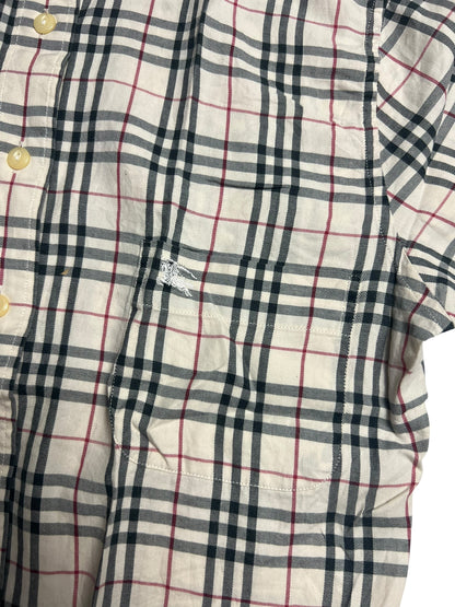Eine Nahaufnahme eines Burberry Hemds in Größe S aus dem ZAZA-Wiederverkauf, mit schwarz-rot-weißem Karomuster, cremefarbenen Knöpfen, Zustandsbewertung 5/10 und einem kleinen gestickten Logo über der Brusttasche.