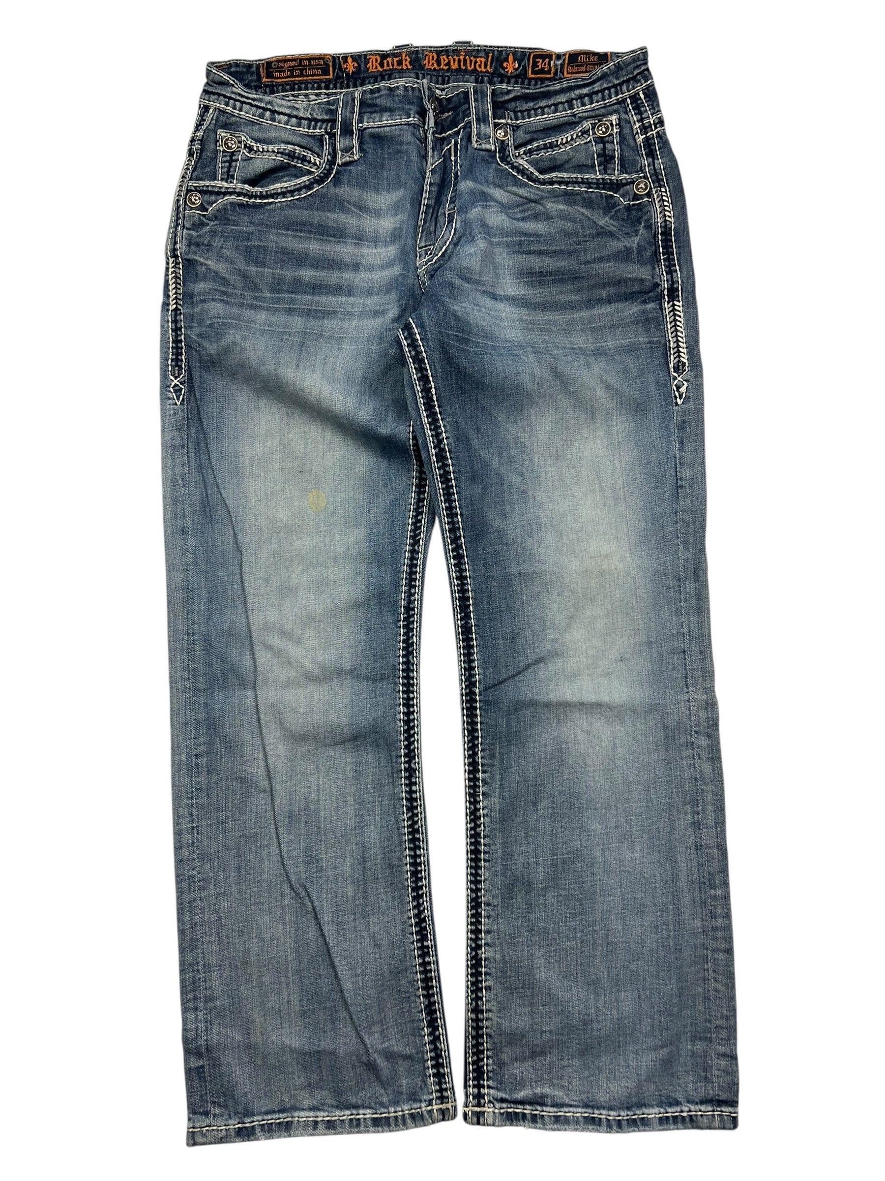 Ein Paar Rock Revival Relaxed Straight/Baggy Jeans von ZAZA resell in Größe 34 (M) aus blauem Denim mit weißen Nähten, Ziertaschen auf der Vorderseite und einem leicht ausgeblichenen Look, flach auf weißem Grund gelegt.