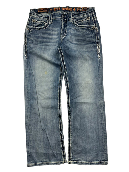 Ein Paar Rock Revival Relaxed Straight/Baggy Jeans von ZAZA resell in Größe 34 (M) aus blauem Denim mit weißen Nähten, Ziertaschen auf der Vorderseite und einem leicht ausgeblichenen Look, flach auf weißem Grund gelegt.