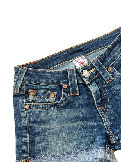 Eine Nahaufnahme der True Religion Shorts von ZAZA resell aus blauem Denim mit kupfernen Nieten, einem Metallknopf, sichtbaren Nähten, einer verblassten Struktur und Etikettendetails: Größe 27 (S).