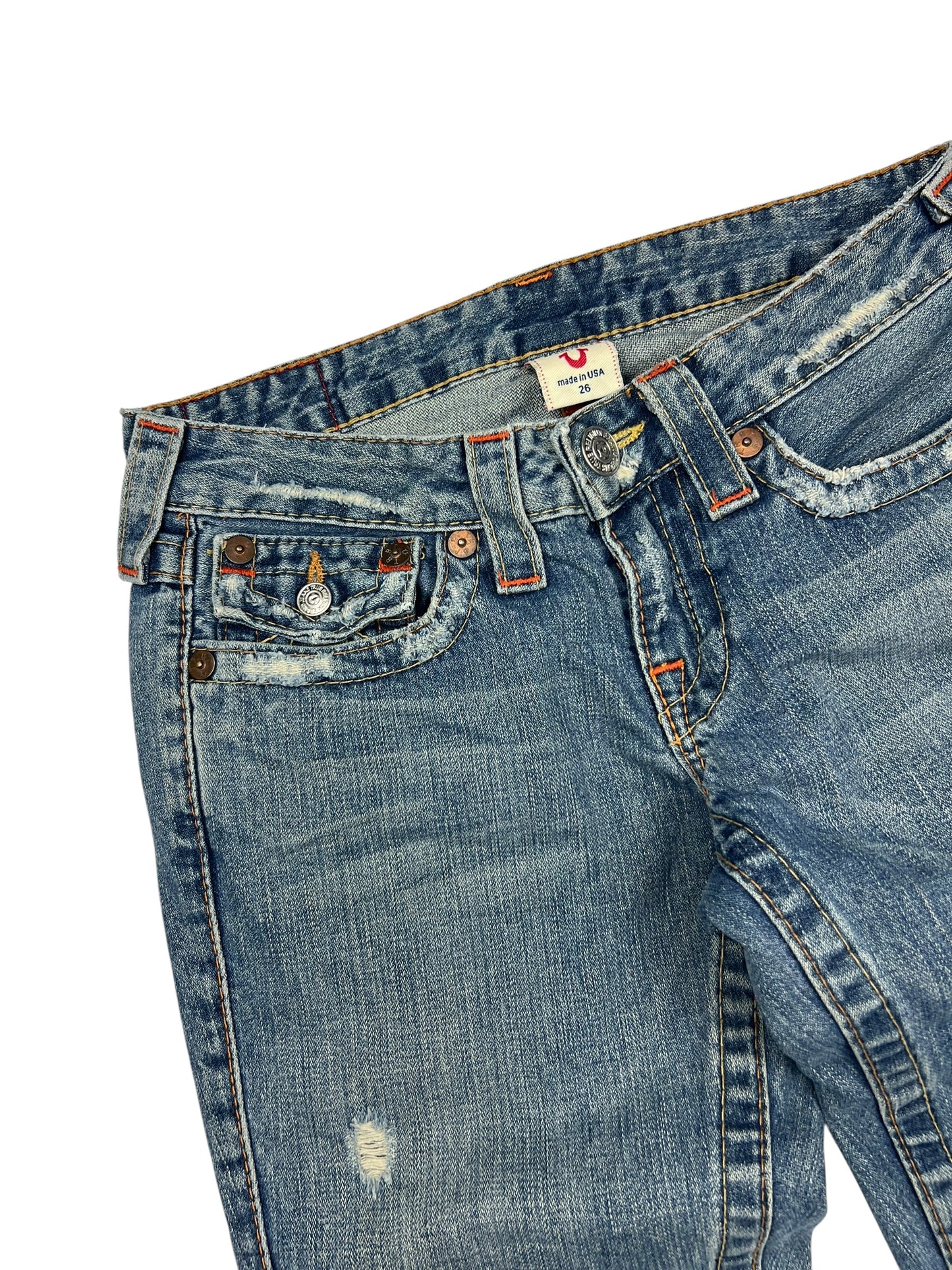 True Religion Joey Low-Rise Bootcut-Jeans in Größe 26 (S) von ZAZA resell, blauer Denim mit verblichenem, gealtertem Finish, sichtbaren Abnutzungen in der Nähe der Taschen und einem kleinen Riss am linken Oberschenkel. Angaben zu Labelgröße und Bundweite vorhanden.