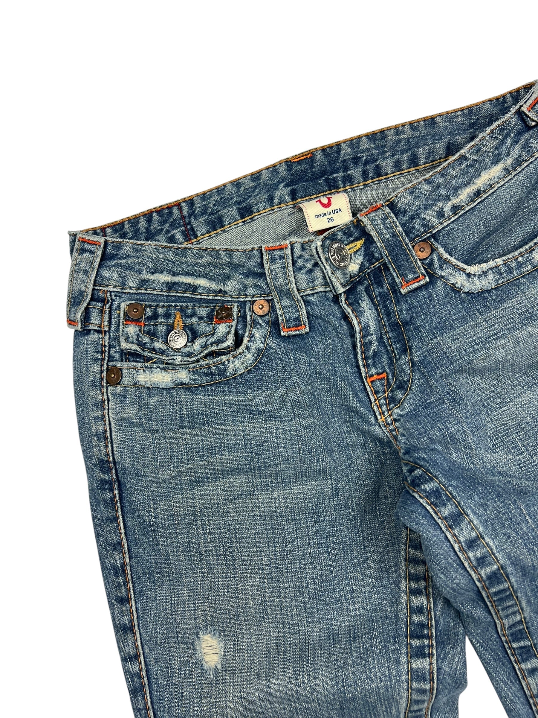 True Religion Joey Low-Rise Bootcut-Jeans in Größe 26 (S) von ZAZA resell, blauer Denim mit verblichenem, gealtertem Finish, sichtbaren Abnutzungen in der Nähe der Taschen und einem kleinen Riss am linken Oberschenkel. Angaben zu Labelgröße und Bundweite vorhanden.