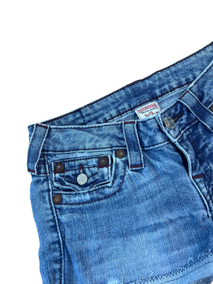 Eine Nahaufnahme des oberen Teils der True Religion Shorts | 25 (XS) von ZAZA resell, die den Bund, die Vordertaschen mit Nieten, die Gürtelschlaufen und einen Metallknopf zeigt. Die Custom Shorts sind sorgfältig genäht vor einem weißen Hintergrund.