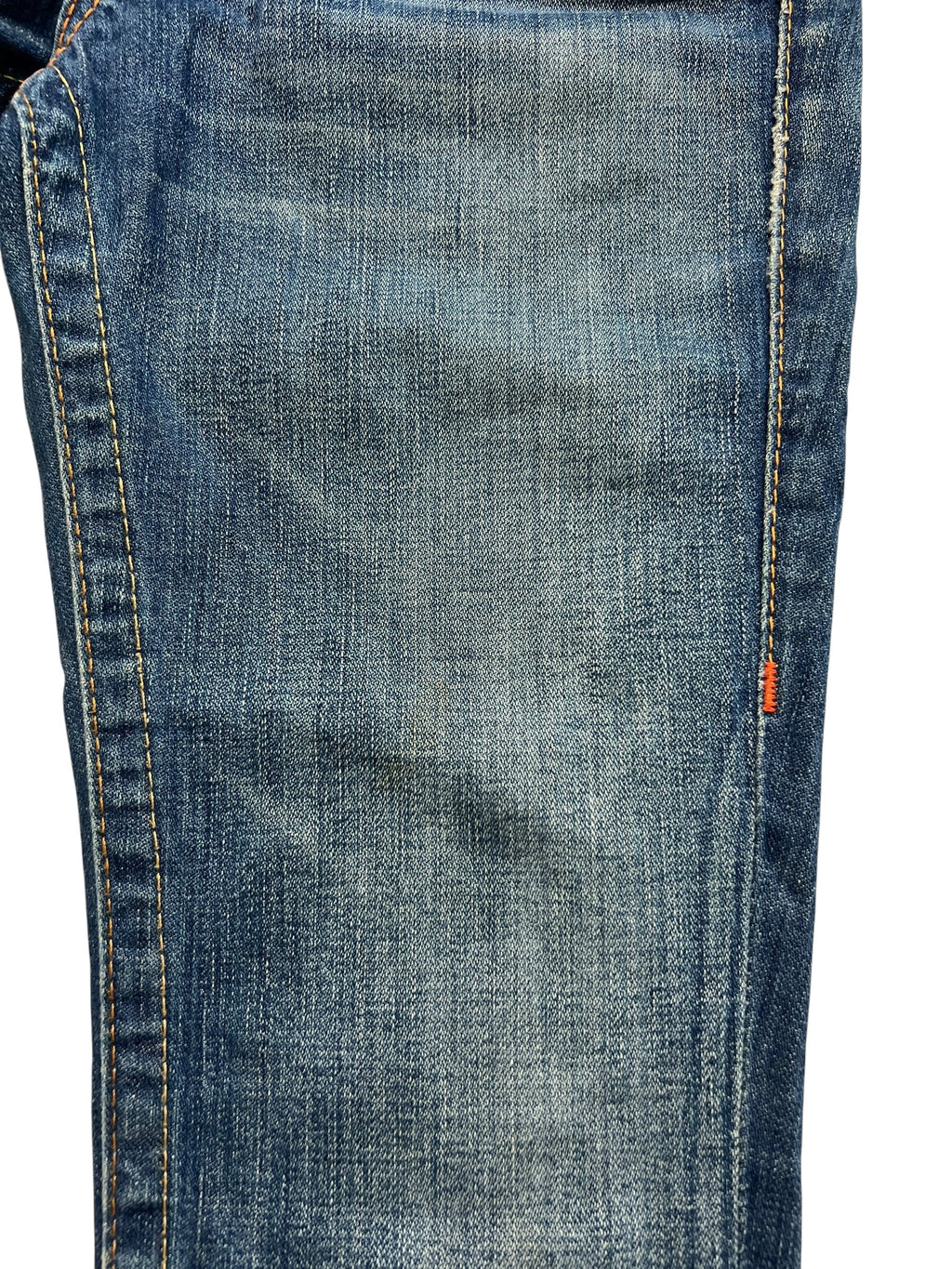 Nahaufnahme der True Religion Billy - Low Rise Straight Jeans (26 S/M) von ZAZA resell, mit blauem Denim, sichtbaren Nähten, verblasster Textur, orangefarbenen Nahtdetails und einem Fokus auf der Bundweite für eine perfekte Passform.