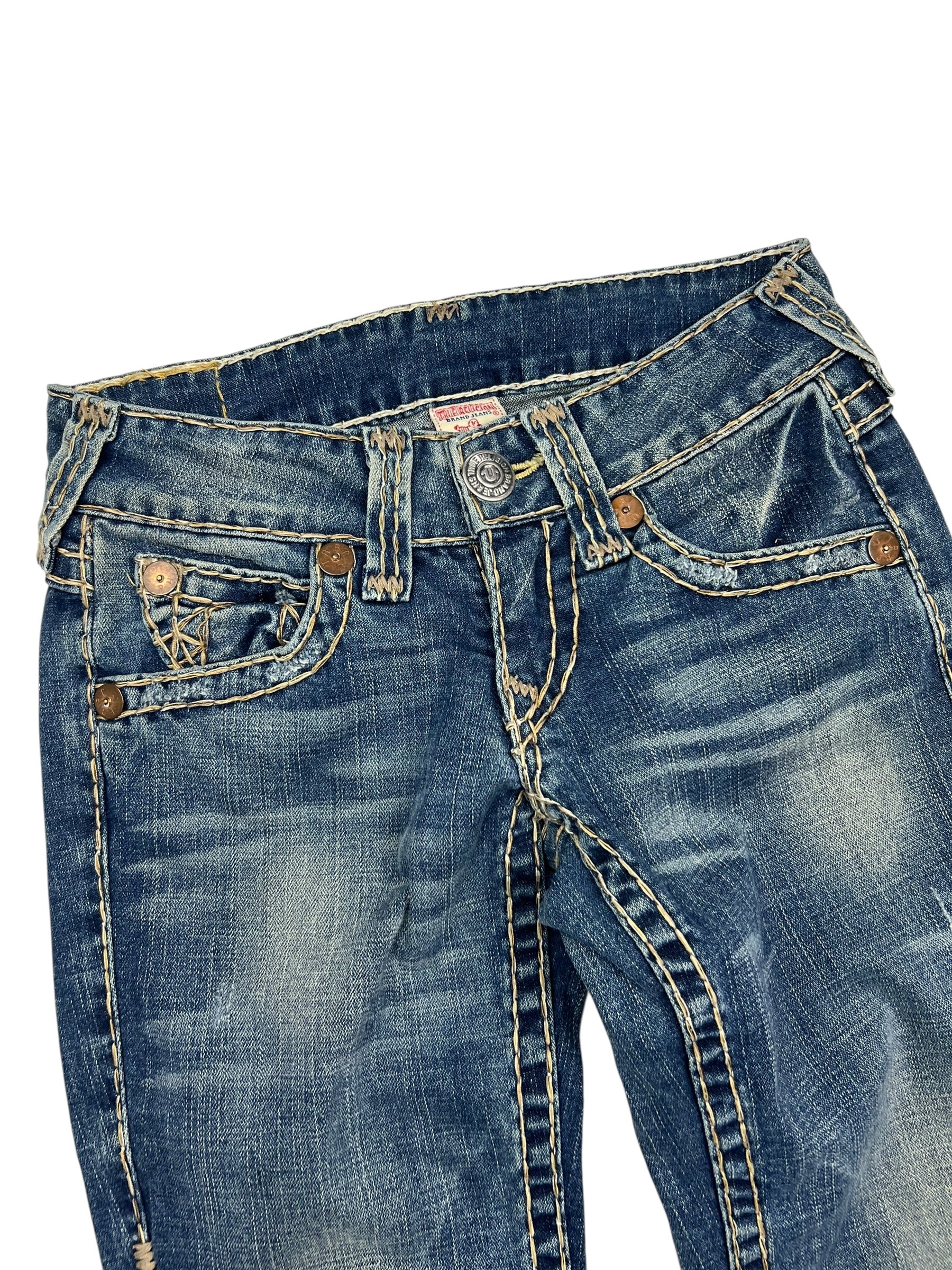 Eine Nahaufnahme der True Religion Joey Super T Low Rise Boot Jeans von ZAZA resell in Größe 26 (S), mit weißen Ziernähten, Knopfverschluss, Gürtelschlaufen, Vordertaschen mit einer detaillierten Münztasche - Bundweite und Labelgröße sorgen für eine ideale Passform.