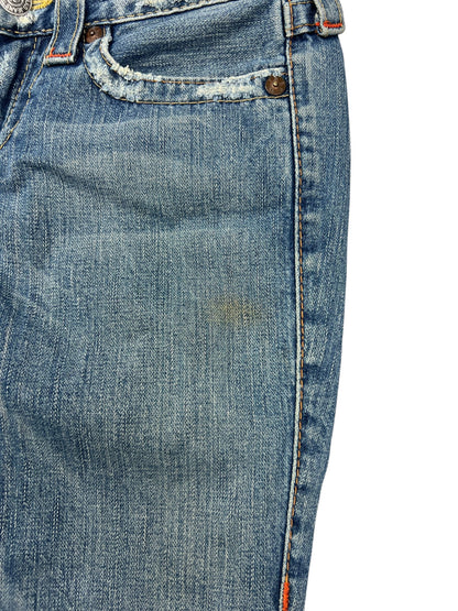 Nahaufnahme der True Religion Joey - Low Rise Boot Jeans (26/S) von ZAZA resell, mit einem kleinen braunen Fleck in der Nähe der Tasche, ausgefranstem Rand und sichtbarer Textur. Subtile Fading Highlights Etikett Größe und Bund Details für fit Referenz.