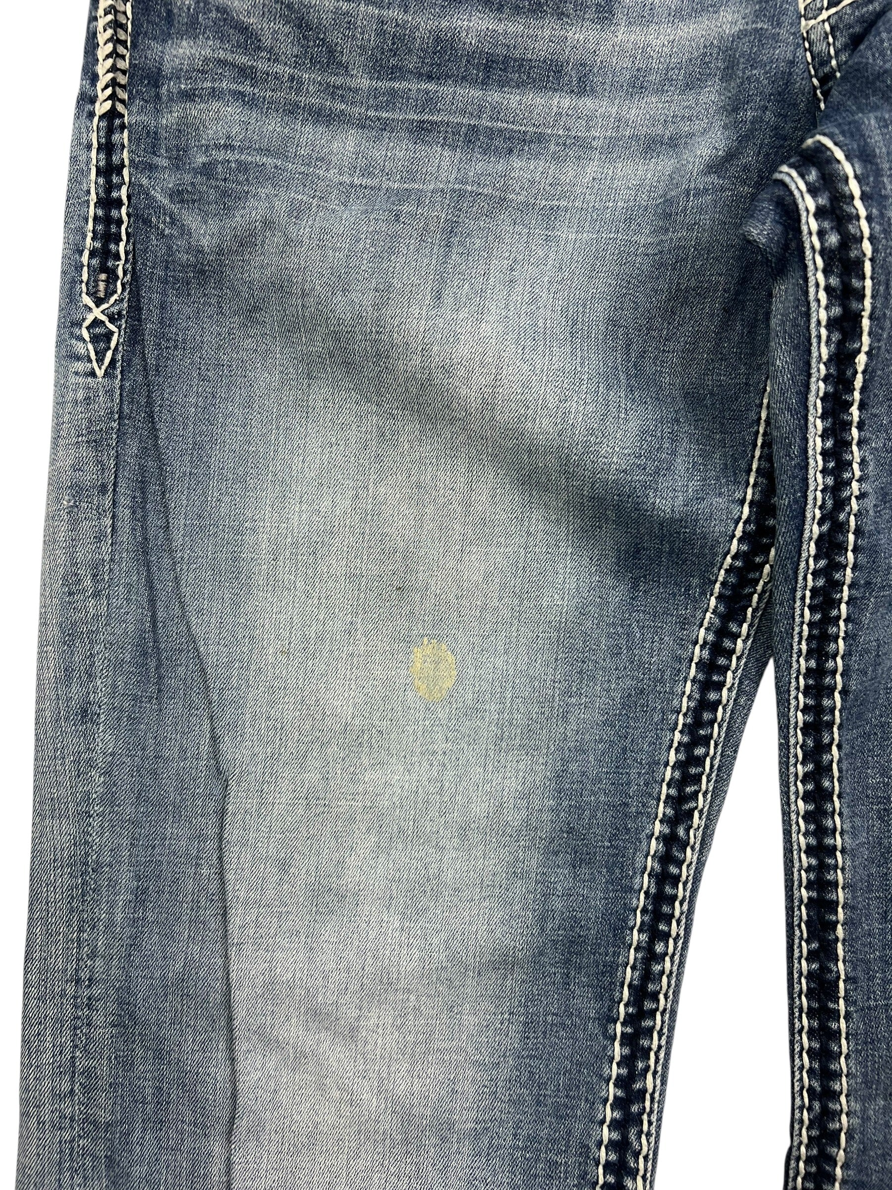 Rock Revival Relaxed Straight/Baggy Jeans von ZAZA resell, Größe 34 (M), blau mit weißen Ziernähten und einem schwachen runden gelben Fleck im Oberschenkelbereich.