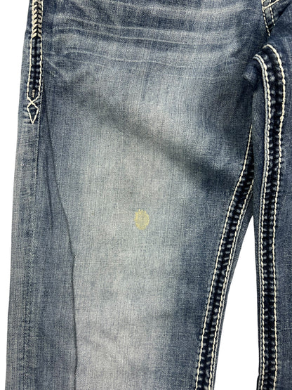 Rock Revival Relaxed Straight/Baggy Jeans von ZAZA resell, Größe 34 (M), blau mit weißen Ziernähten und einem schwachen runden gelben Fleck im Oberschenkelbereich.