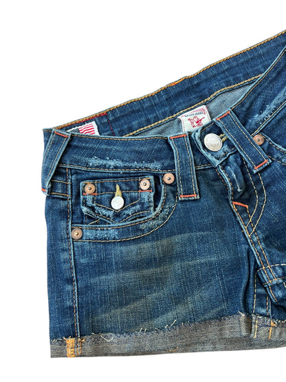 Die True Religion Shorts | 23 (XS) von ZAZA resell haben einen ausgefransten, abgeschnittenen Saum mit Fronttasche, Gürtelschlaufen, Kupfernieten und detaillierte Nähte - alles auf einem knackigen weißen Hintergrund für den klassischen Cowboy-Look.