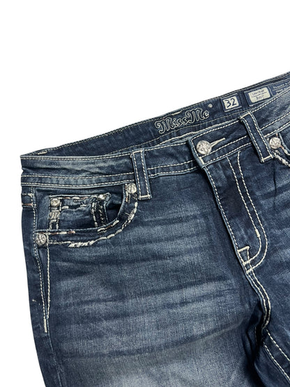 Nahaufnahme des Bundes und des oberen Teils der dunkelblauen Miss Me Low Rise Boot Jeans von ZAZA resell, Größe 32 (L), mit weißen Kontrastnähten, Gürtelschlaufen, einem Knopf und einer dekorativen Münztasche.